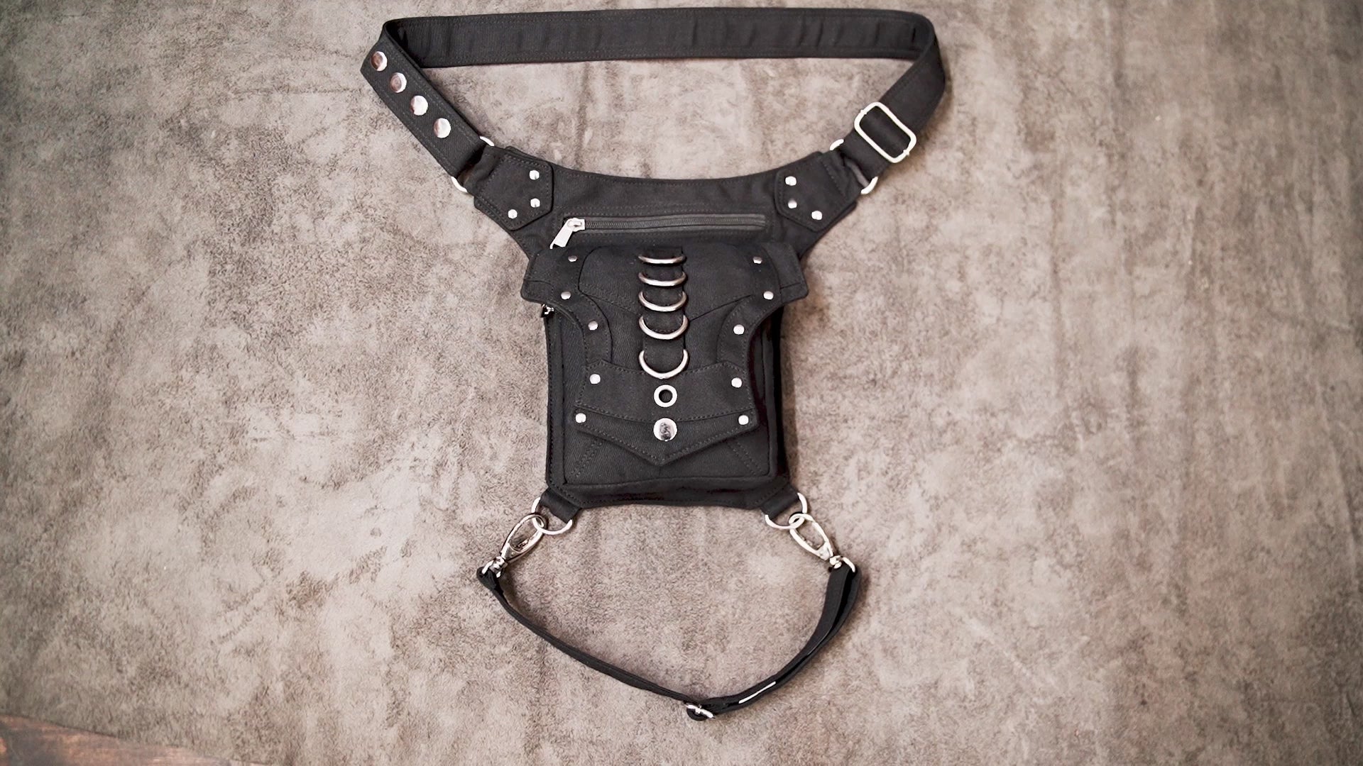 Adjustable black utility waist pouch with metal hardware.