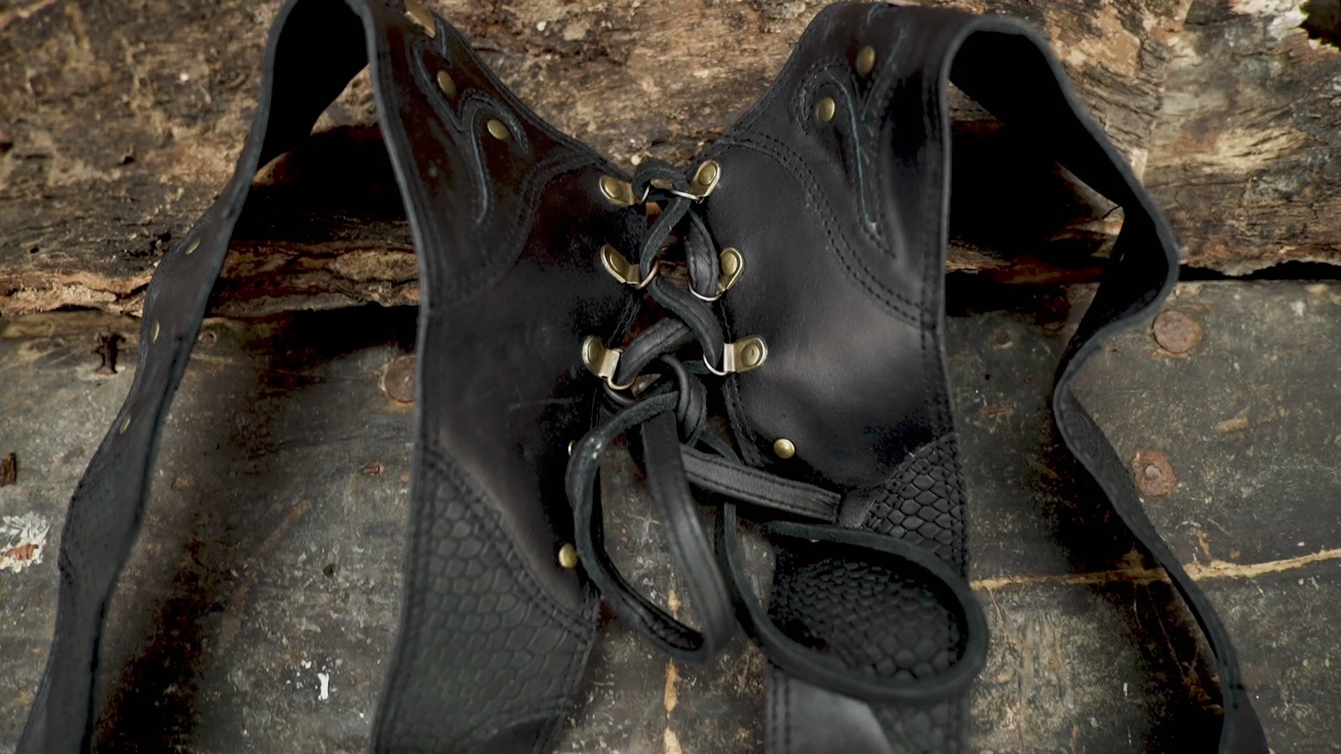 Handmade black leather holster bag with studded design and laced back