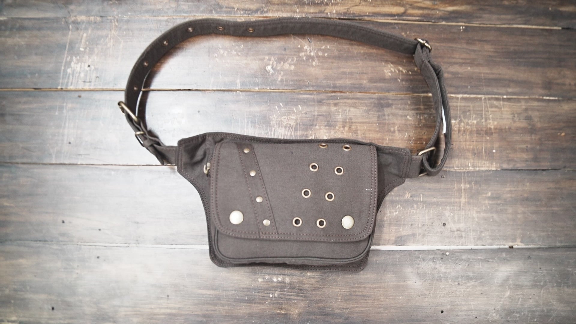 Steampunk style brown hip bag with metal eyelets and flap