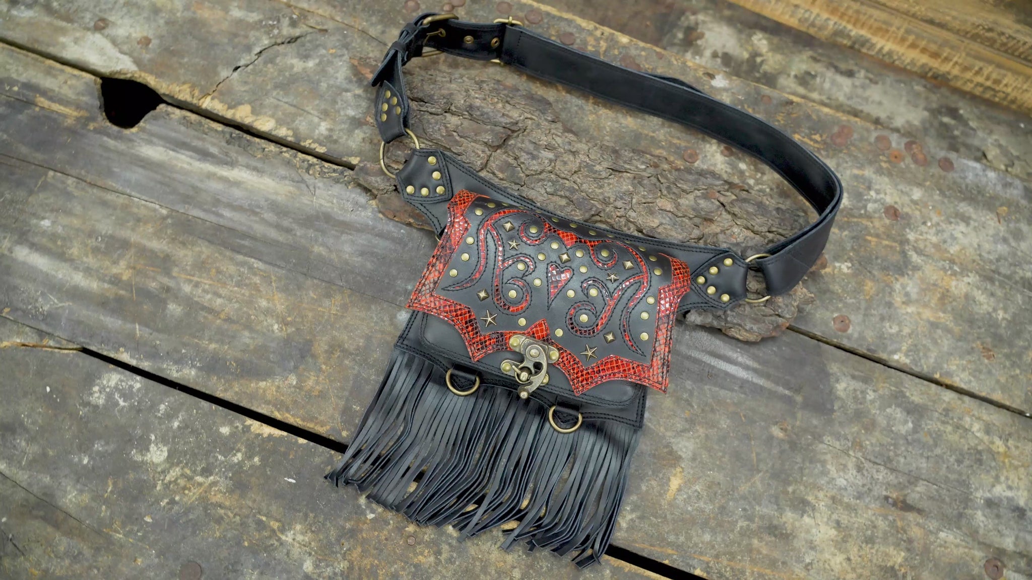 Western leather waist belt with studded design, red textured leather, and long fringe