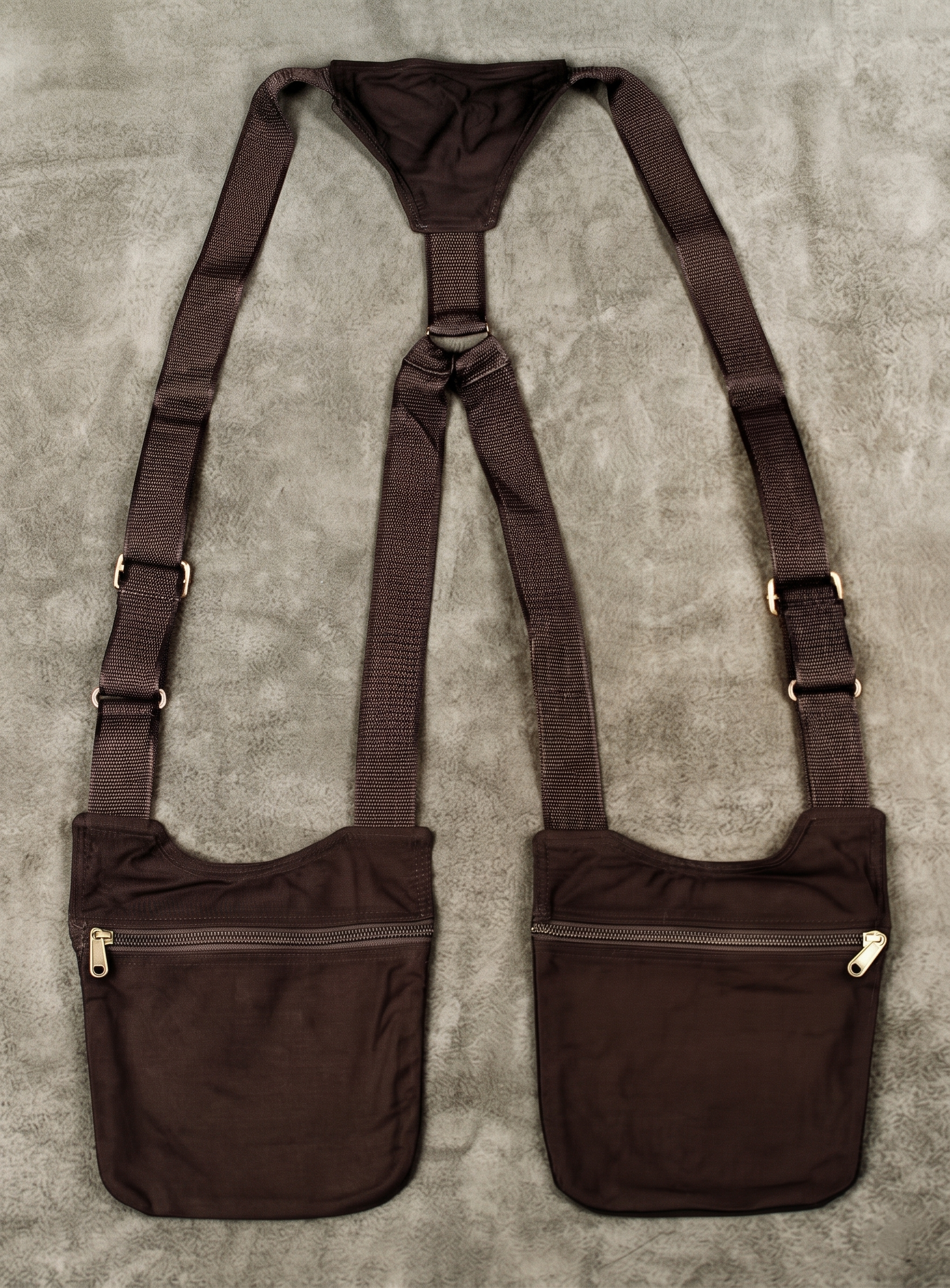 Multi-pocket tactical chest bag and harness rig with durable canvas construction and brass accents.